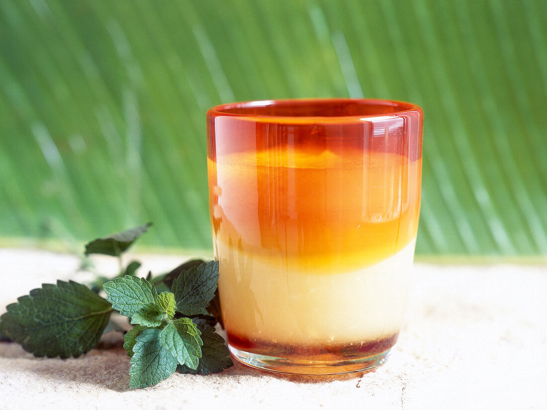 Melon with ginger juice in glass beside mint leaves