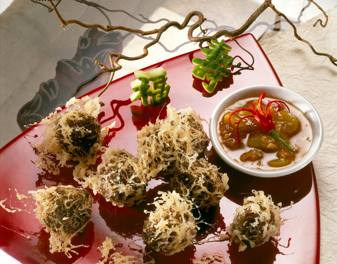 Euro-Asian cuisine of meatballs wrapped and fried with glass noodles and sauce bowl