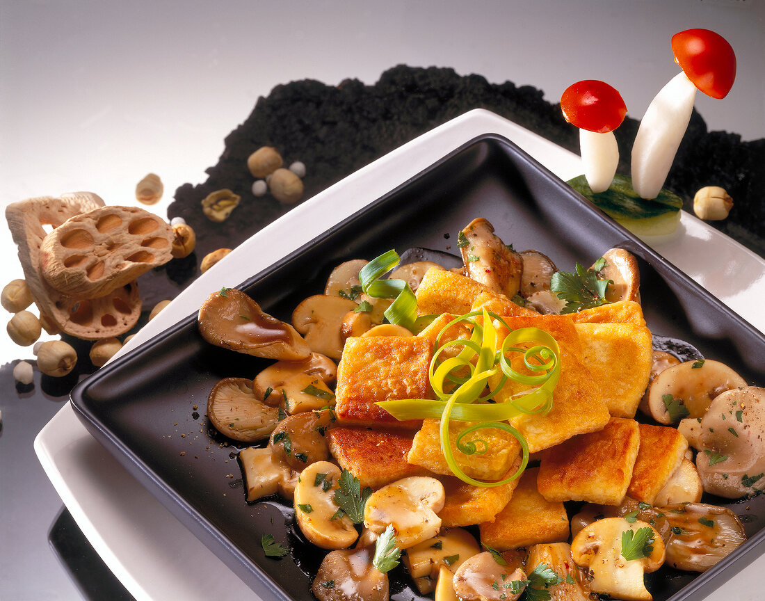Fried tofu with oyster mushrooms on dish, Euro-Asian cuisine