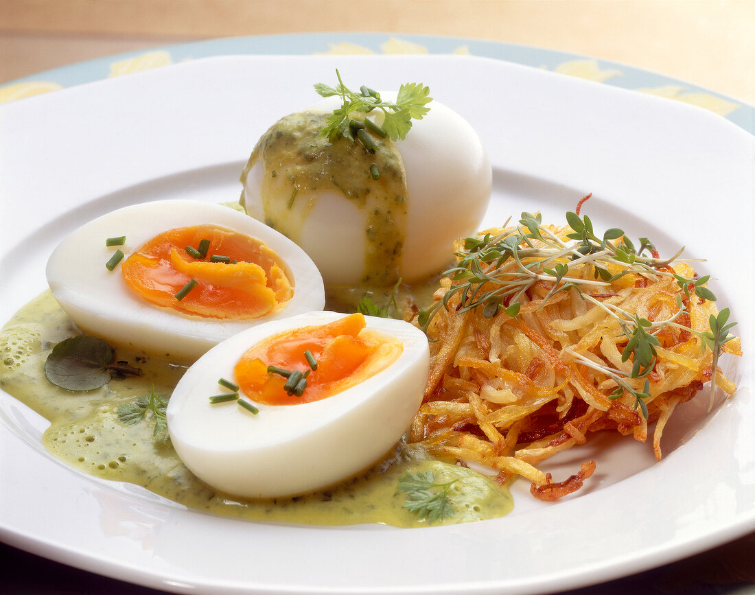 Close-up of eggs in herb sauce and rosti on dish