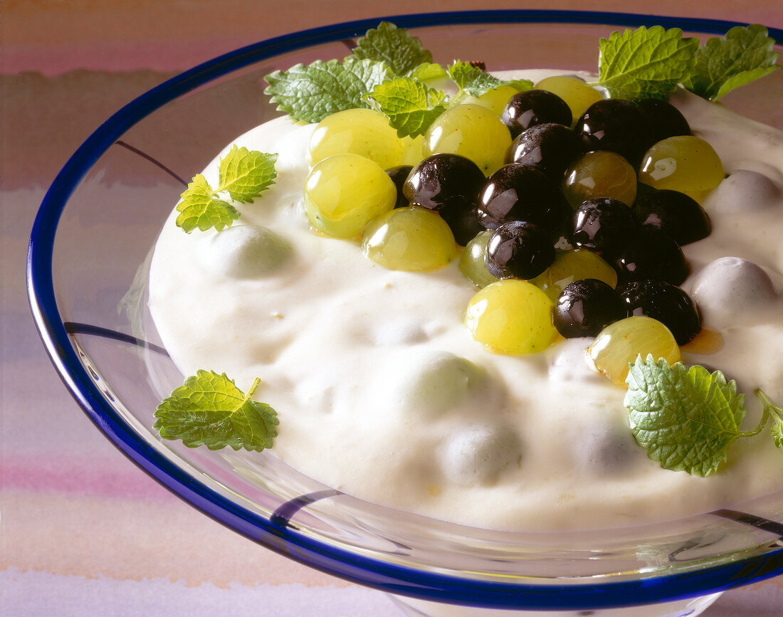 Green and blue grapes with cheese cream icing on glass dish
