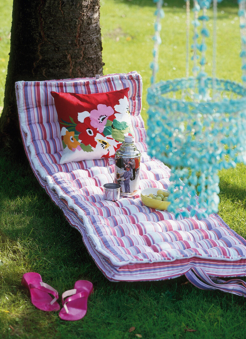 Colourful striped cotton mattress laid in lawn