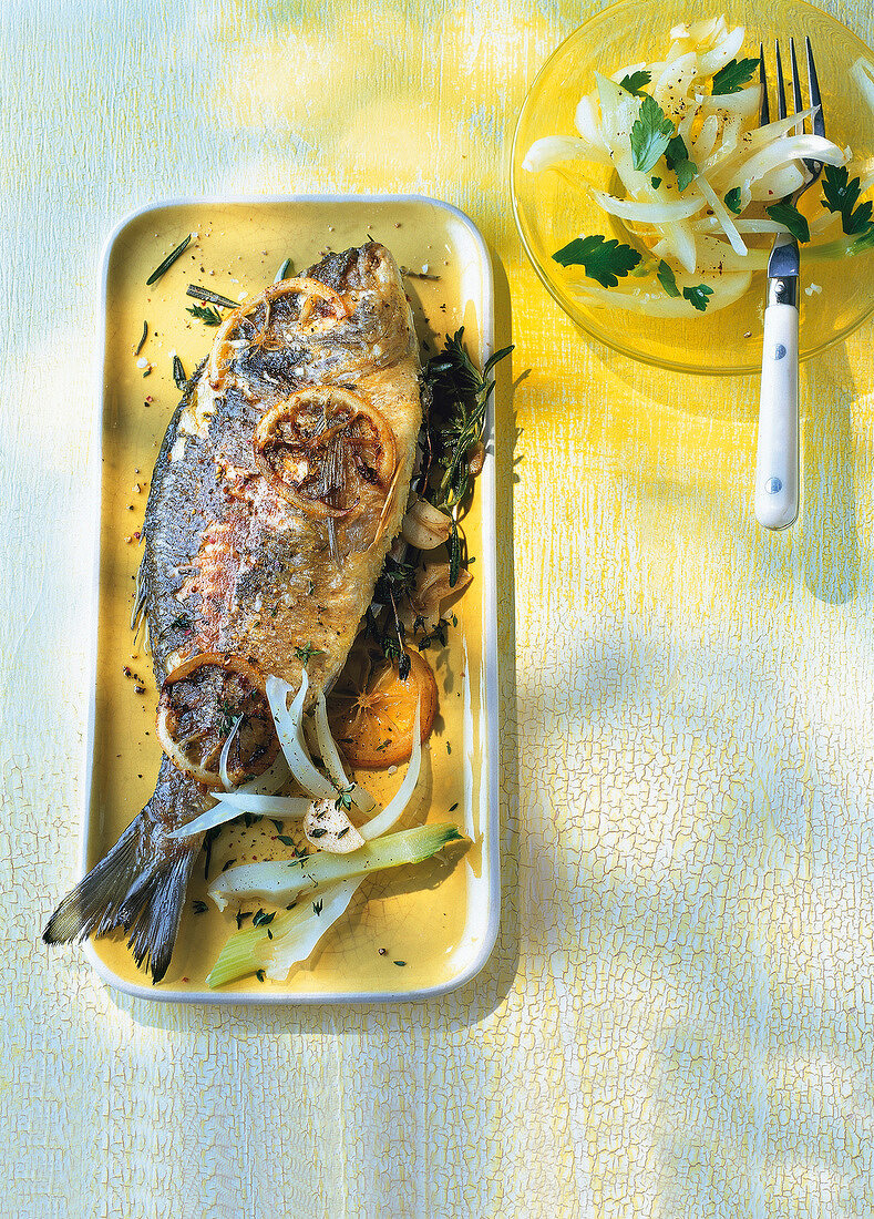 Sea bream with fennel in serving dish, overhead view