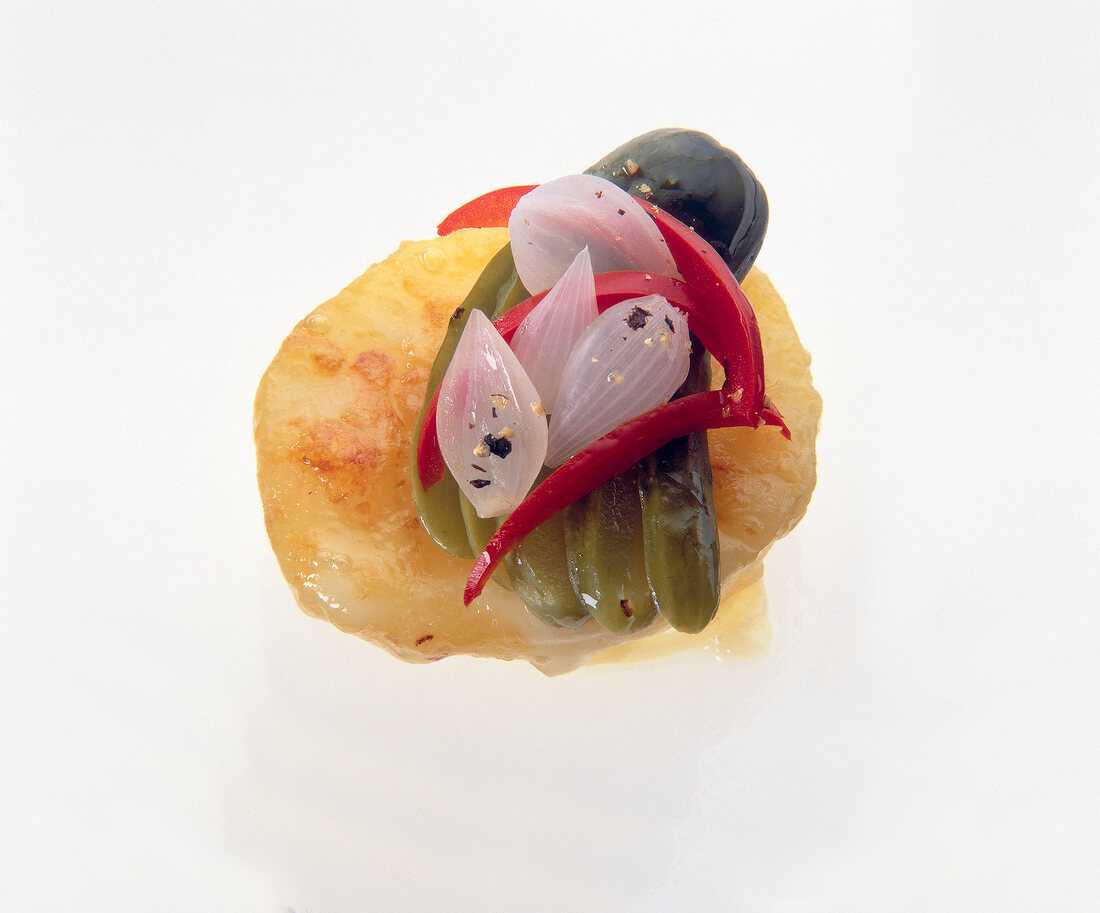 Close-up of cheese, gherkins, pickled onions and peppers on potatoes
