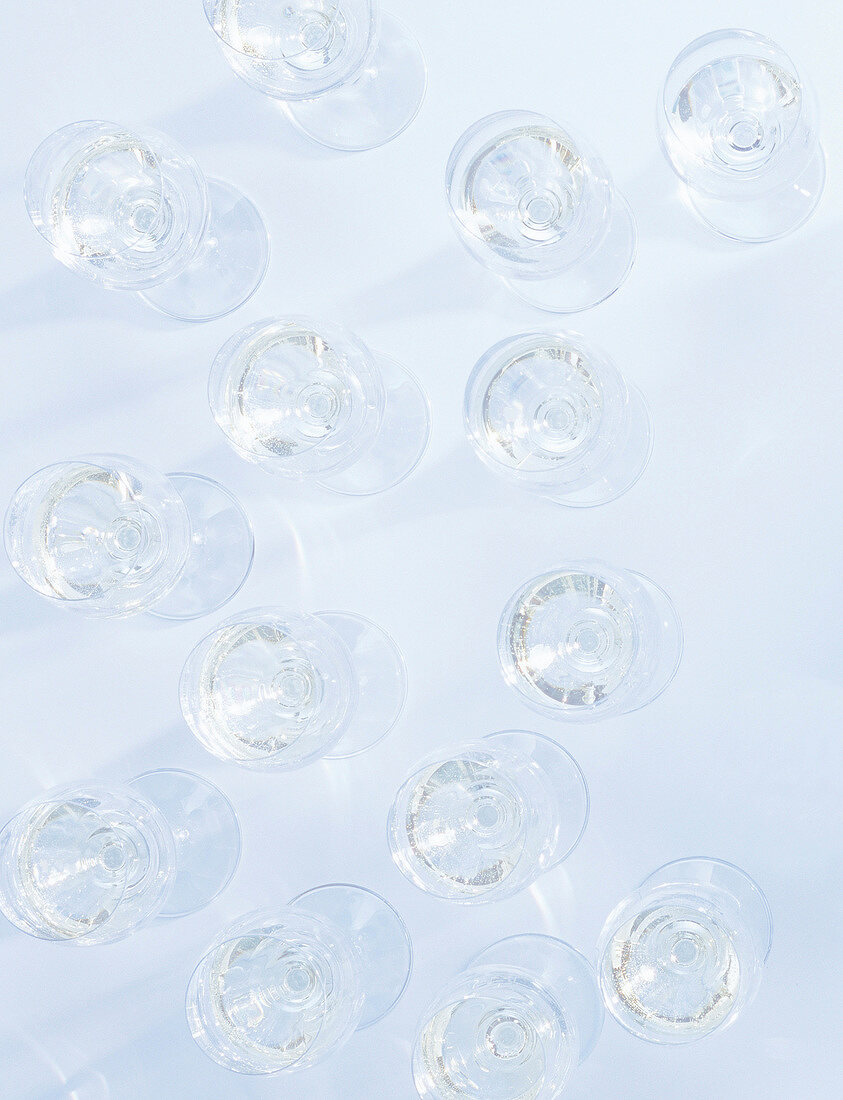 Glasses of white wine on white background, elevated view