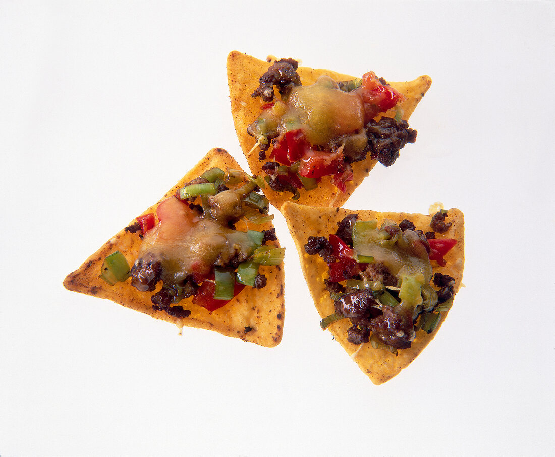 Close-up of tortilla chips with beefsteak hack, tomatoes, cheese and taco sauce