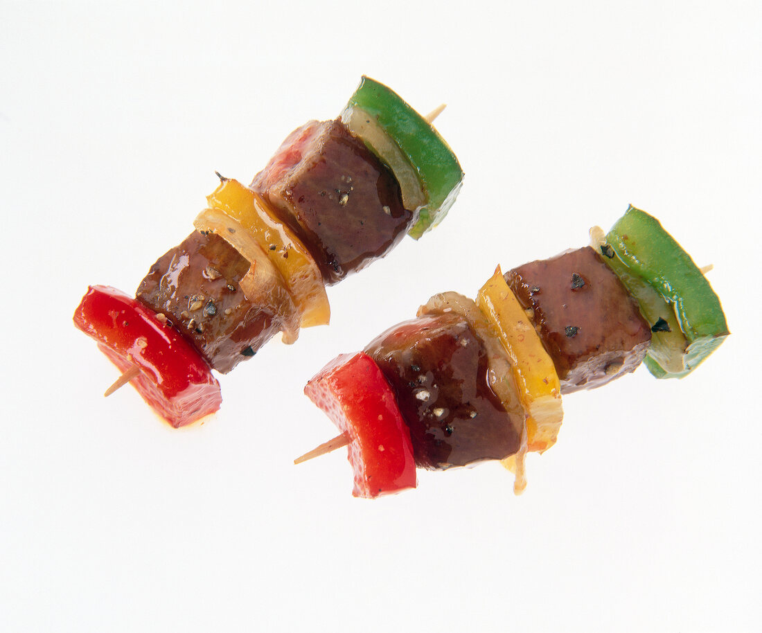 Close-up of colorful kebabs with chilly sauce, peppers, shallots and rump steak