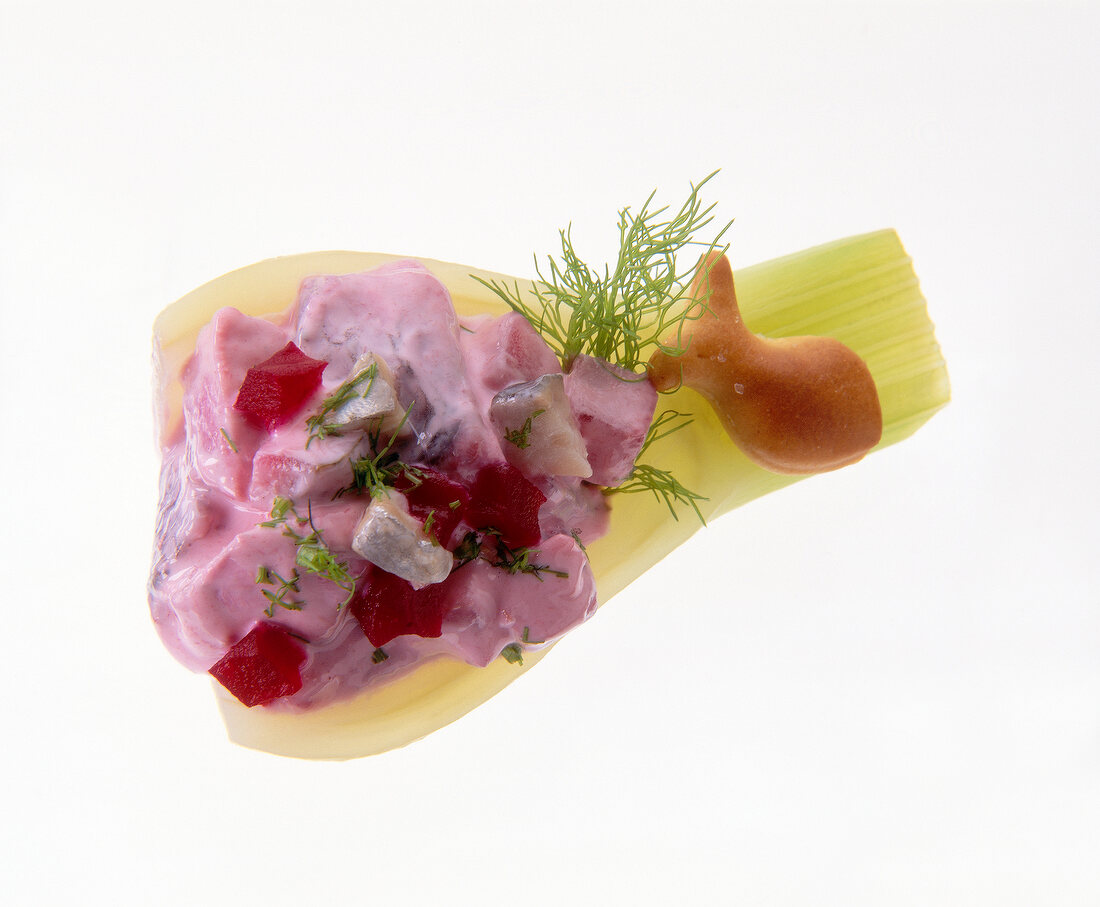 Close-up of fennel bites with red herring salad and dill on white background