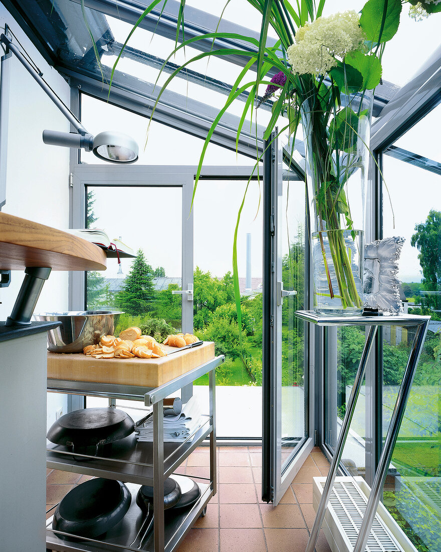 Open air kitchen with flower vase near garden