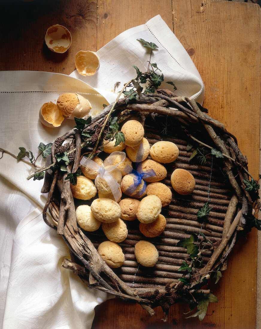 Wicker basket with baked eggs on wooden table for Easter