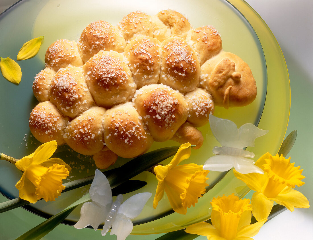Lamb shaped crispy rolls with yellow flowers and white butterflies on glass