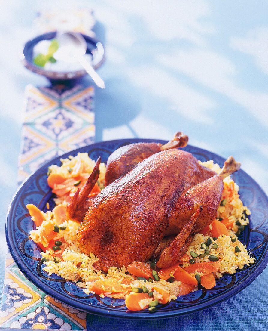 Moroccan roasted chicken served with rice and vegetables on plate