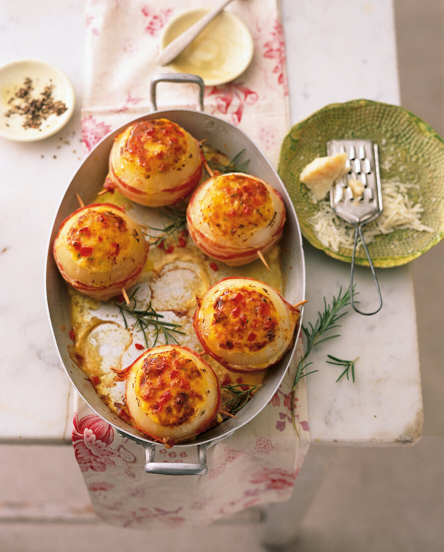 Zwiebeln mit Speck und Tomate, in einer Auflaufform, überbacken