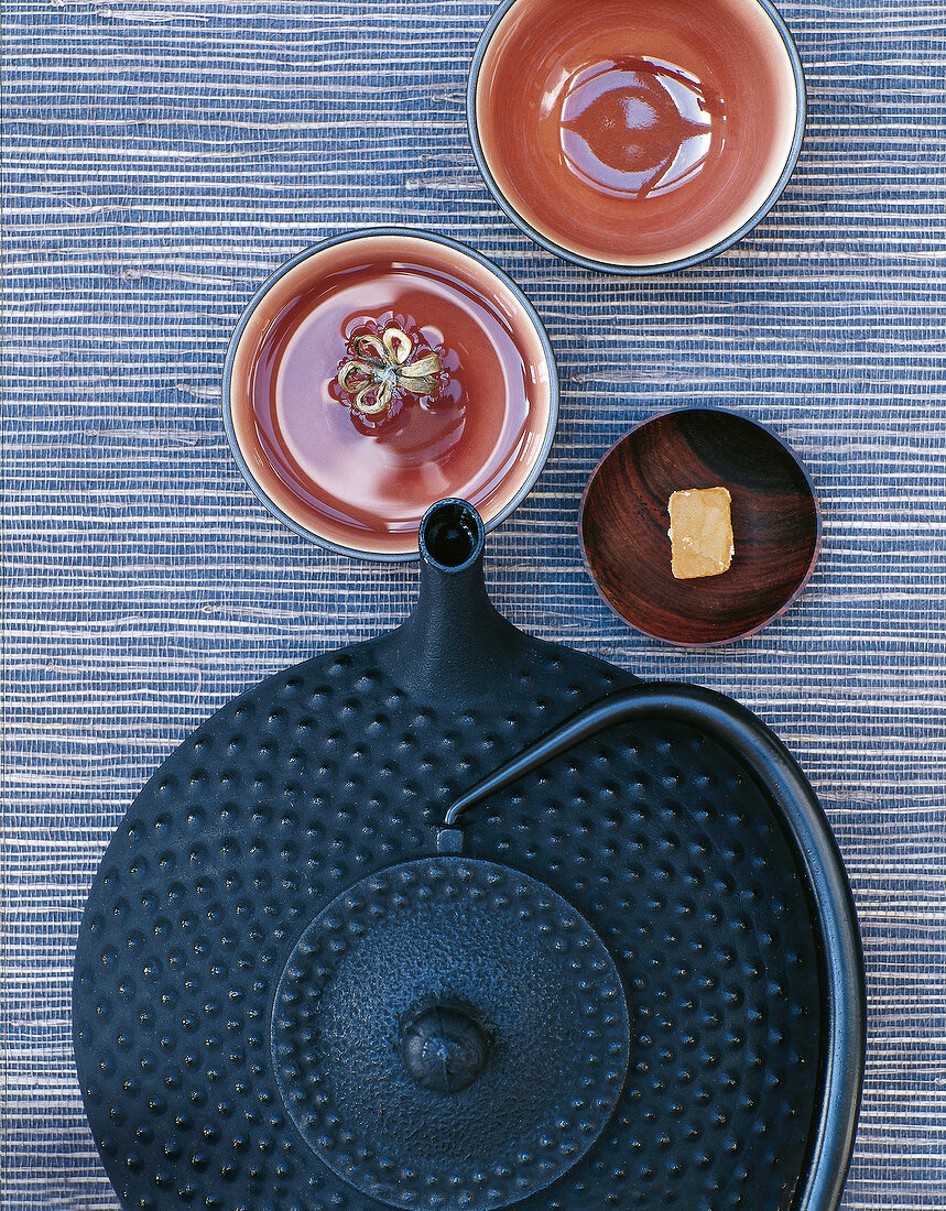 Gusseiserne Teekanne daneben Ton- schalen und kandierter Ingwer, Japan