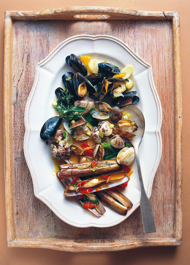 Three different dishes of mussels in serving dish