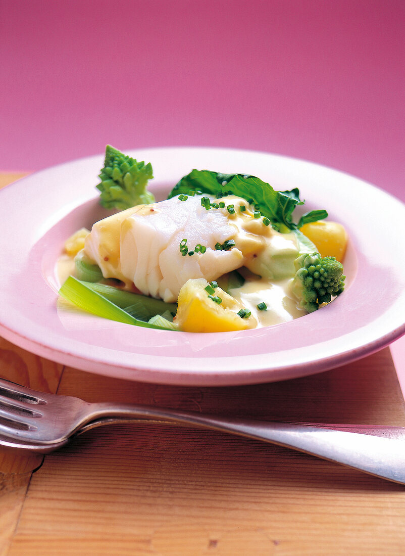 Close-up of cod in mustard sauce in pink plate