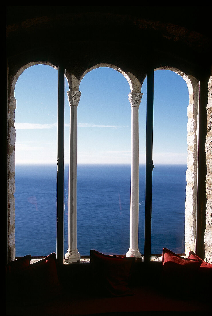 Blick aus dem Fenster mit weißen antiken Säulen auf Meer und Himmel