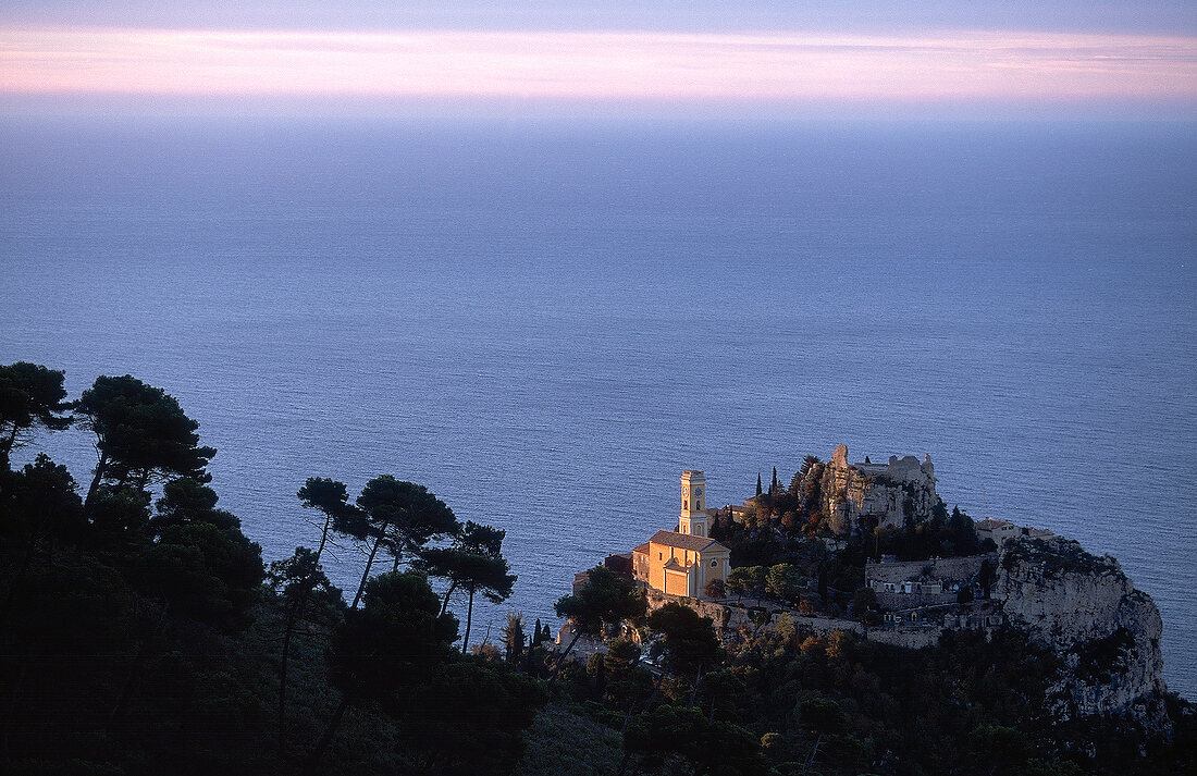 View of sea and ruined castle and church at dusk