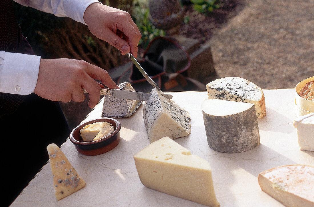 Woman cutting cheese with knife