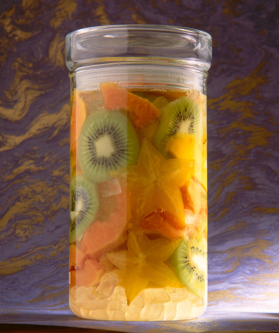 Exotische Früchte in Himbeergeist im Glas: Karambole, Kiwi, Papaya, Mango