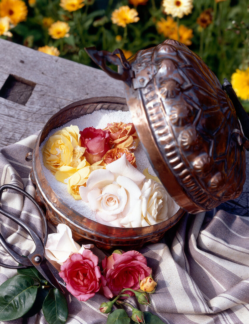 Decorative metal box filled with salt and colourful roses