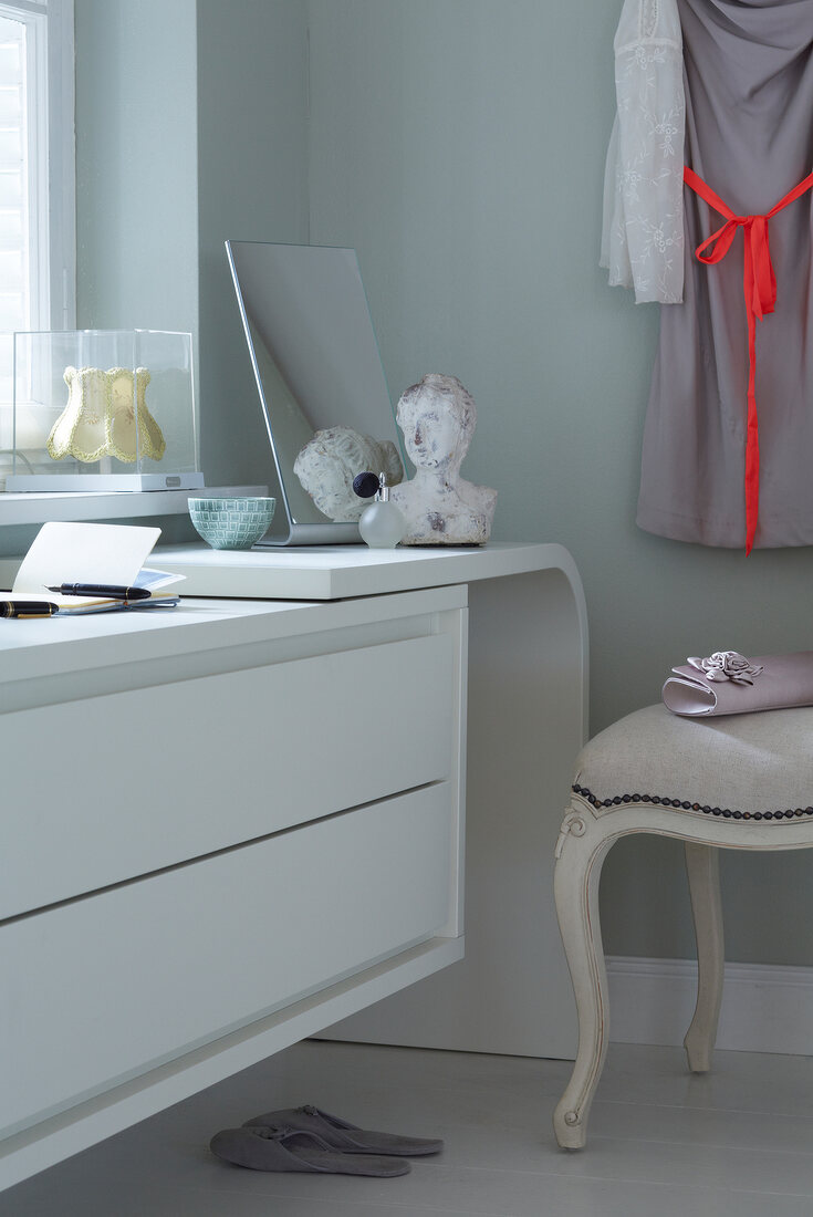 A mirror and a bust on a sideboard extension