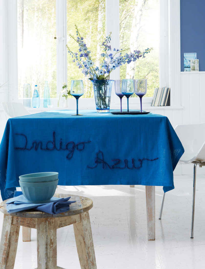 Tisch mit azurblauer bestickter Tischdecke