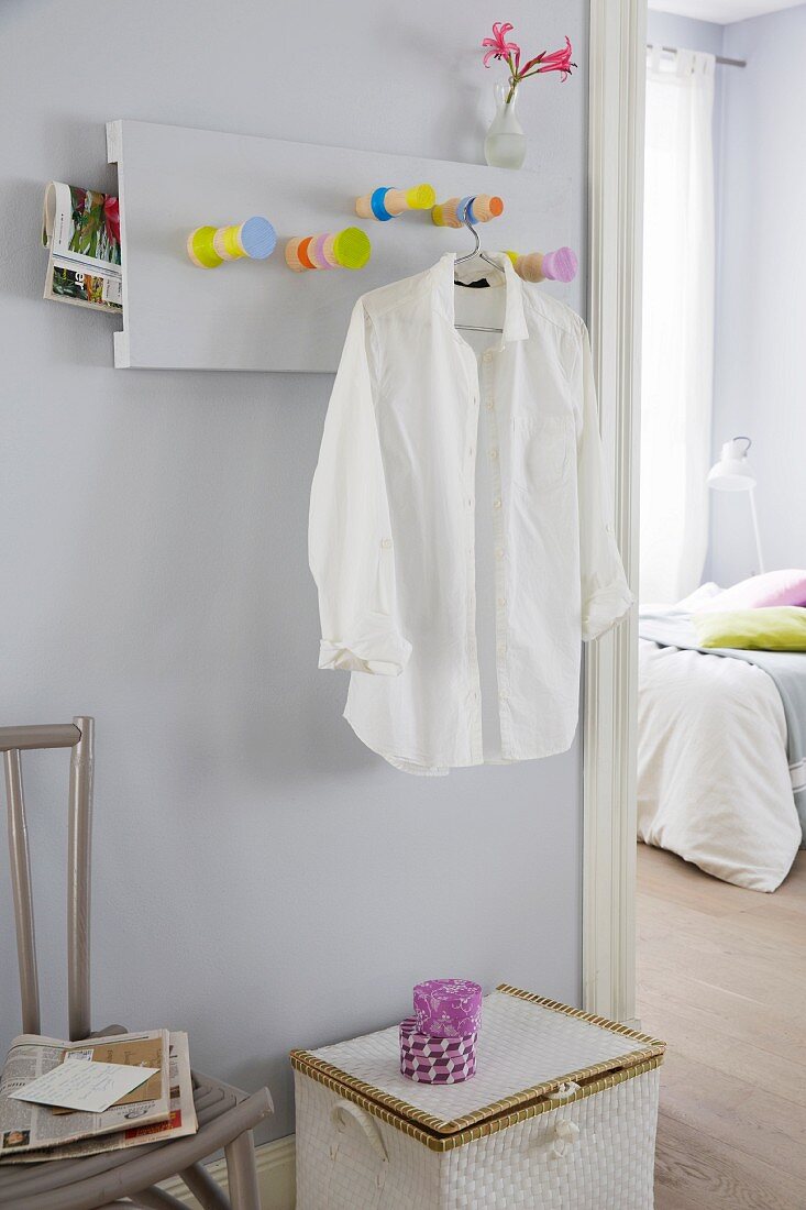 A homemade coat rack made from table legs with a white shirt on a hanger