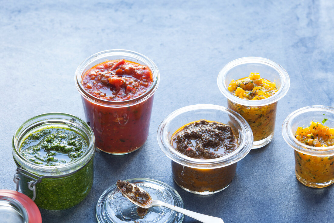 Various sauces and pestos in jars