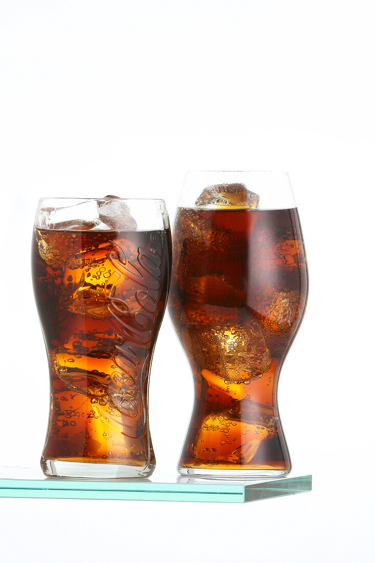 Two glasses of cola against a white background