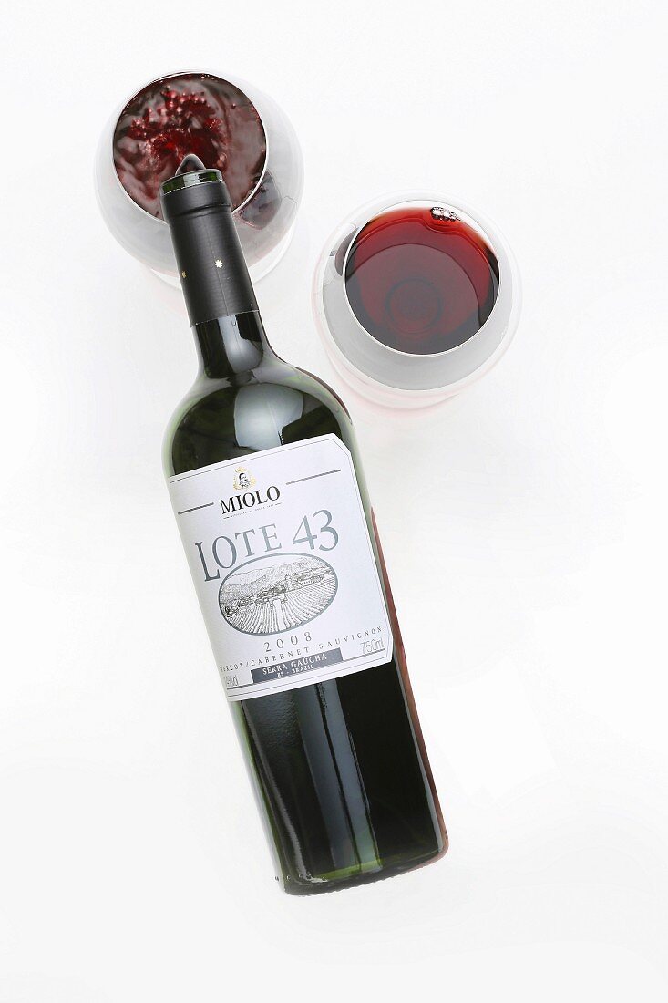 Rotwein wird aus Flasche in Gläser eingeschenkt
