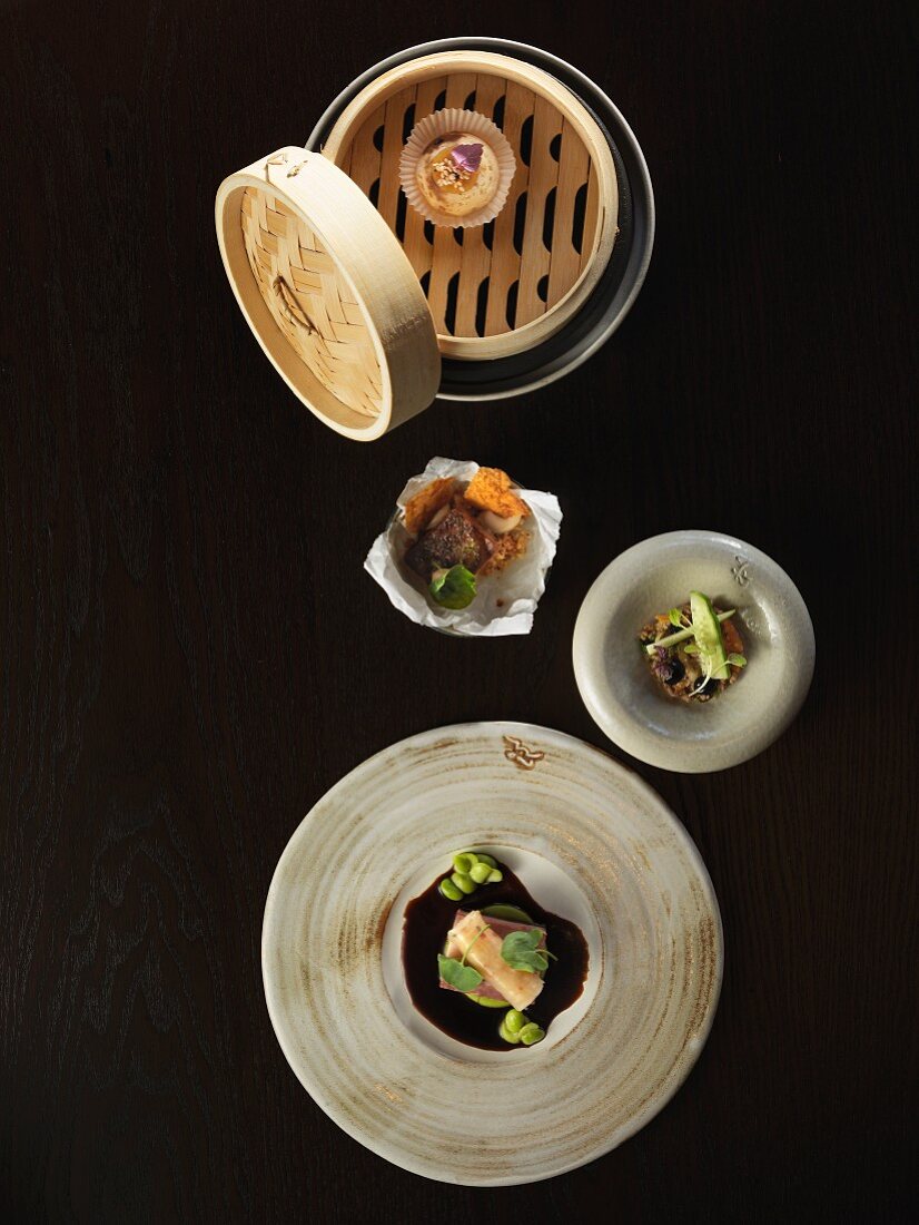 Various oriental appetizers on a dark surface