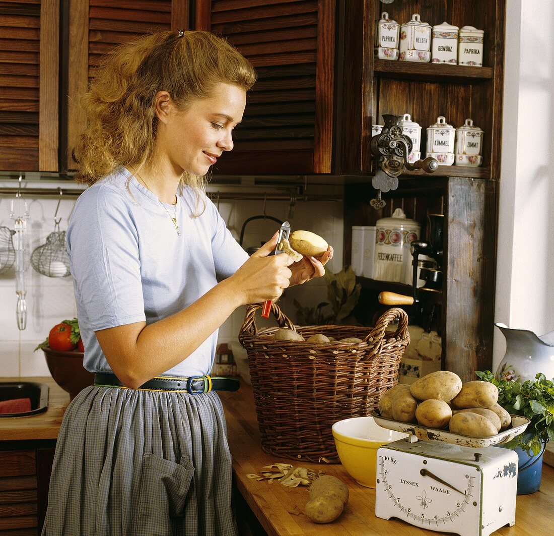 Hausfrau beim Kartoffelschälen in der Küche