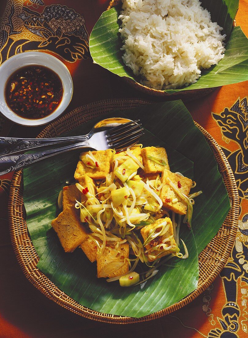 Tofu with vegetables & sprouts, a bowl of rice, chili sauce