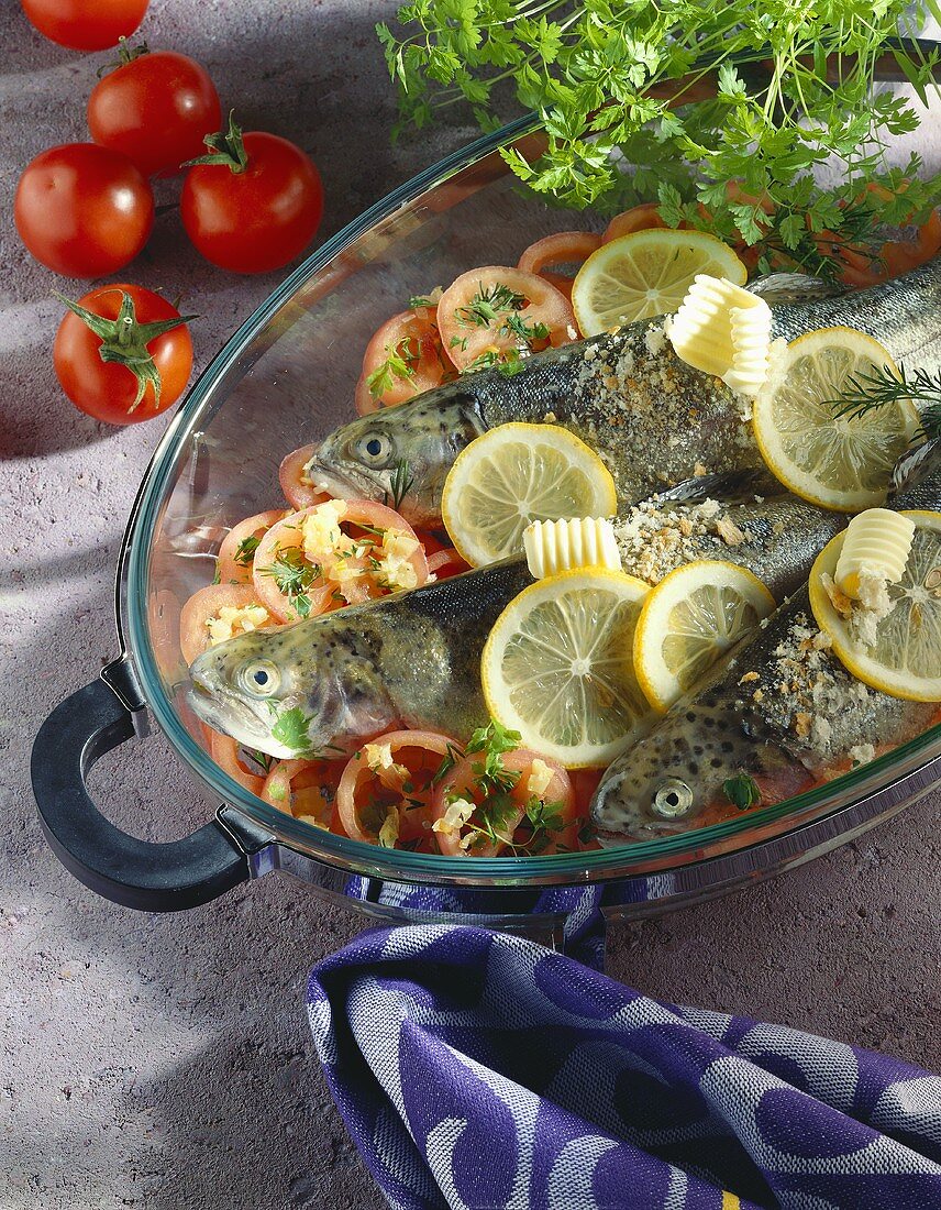 Forelle blau auf Tomatenscheiben und Zwiebeln