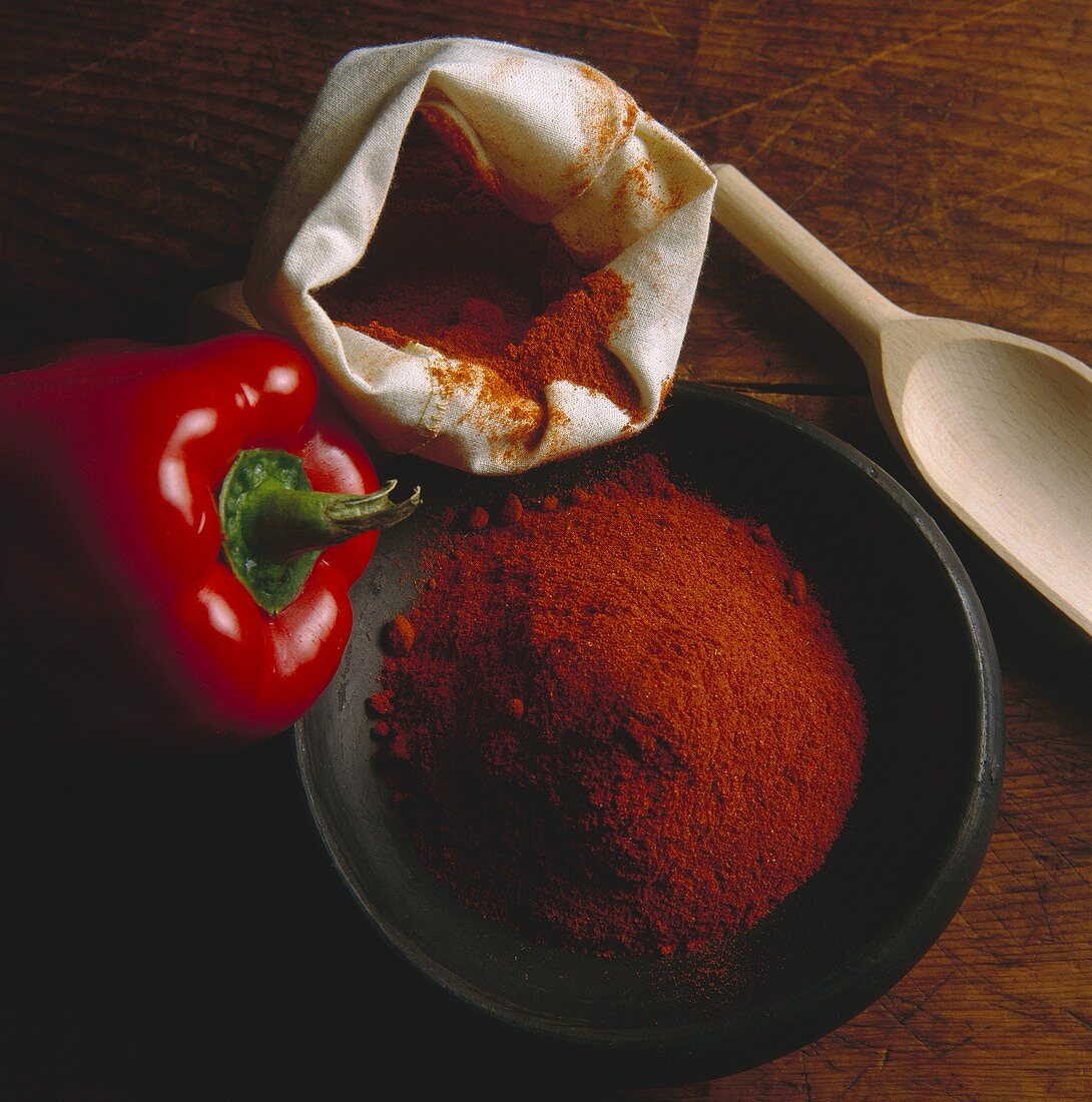 A Bowl and Bag of Paprika and a Red Bell Pepper