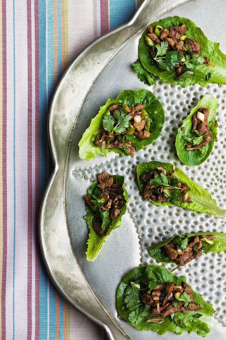 Pork and coriander on lettuce leaves