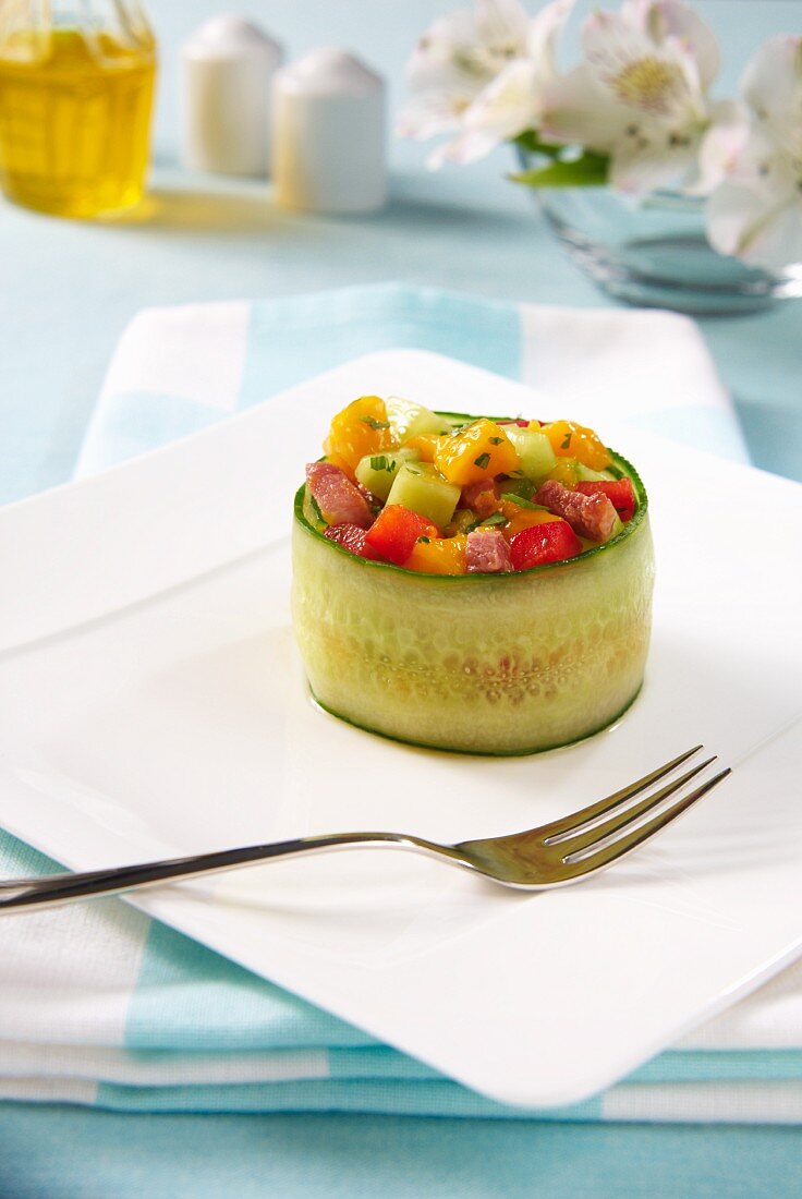 A stuffed cucumber roll filled with mango salad, pepper, cucumber and bacon