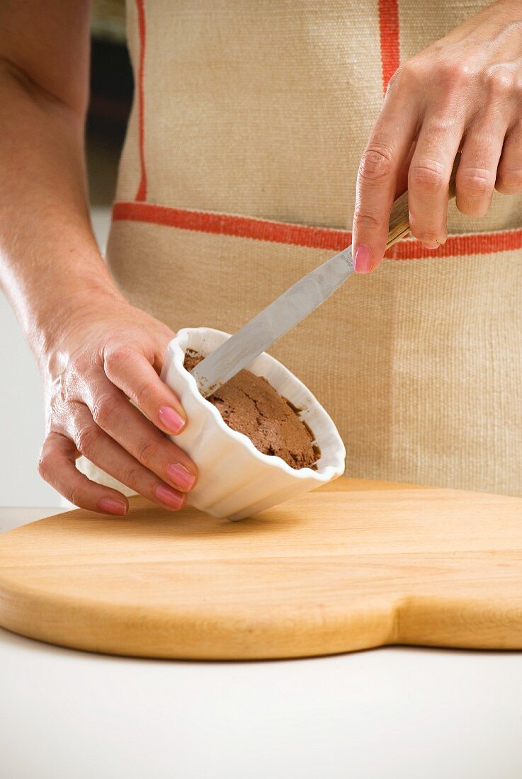 An individual chocolate cake being turned out of the mould