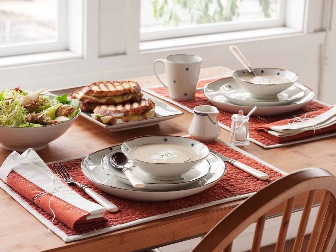 Table Setting with Soup, Grilled Sandwiches and Salad