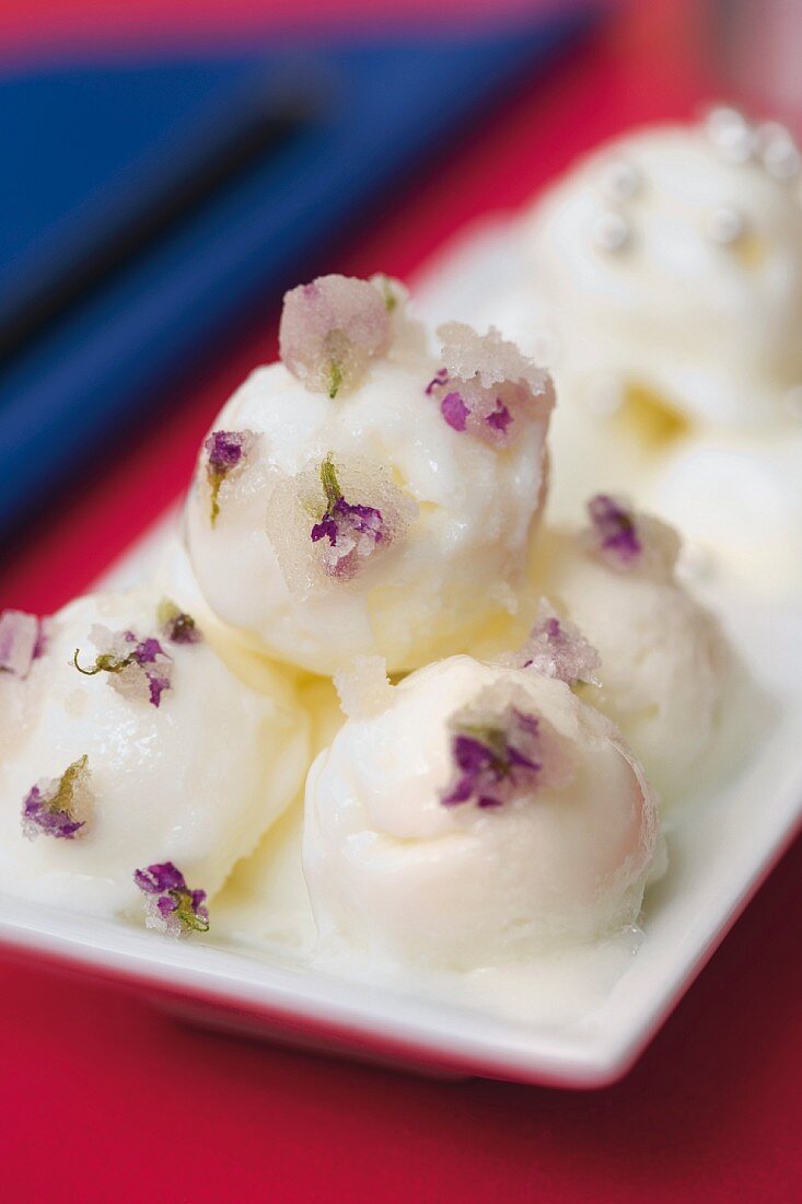 Mini scoops of vanilla ice cream with iced viola flowers for the sweet fondue