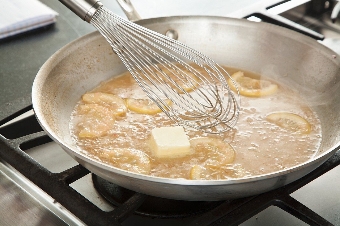 Whisking Butter Into Piccata Sauce in a Skillet