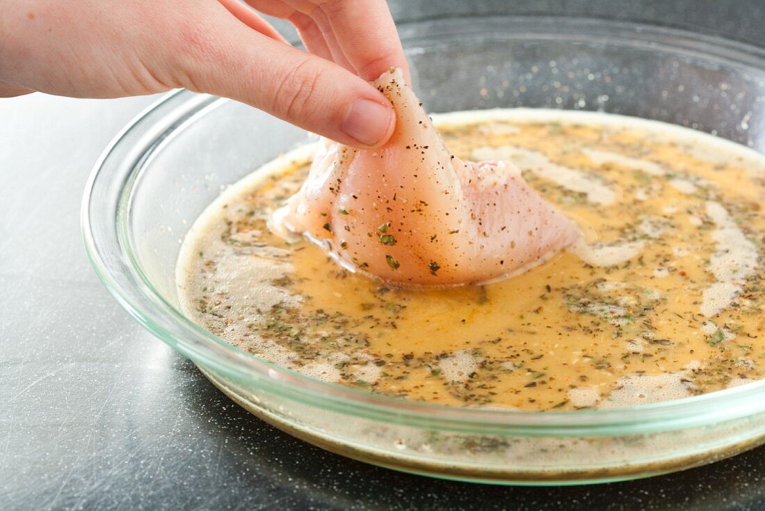 Dipping Chicken in Seasoned Egg; Step in Making Crunchy Baked Chicken