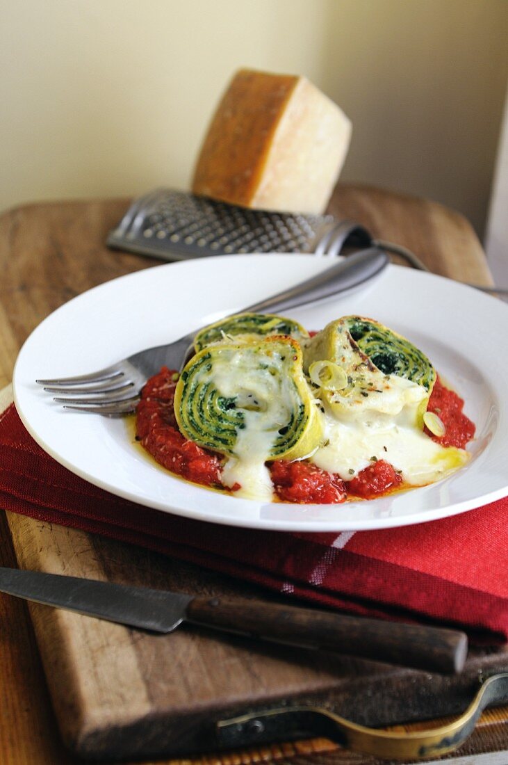 Pasta roulade filled with spinach and ricotta on a tomato and bechamel sauce