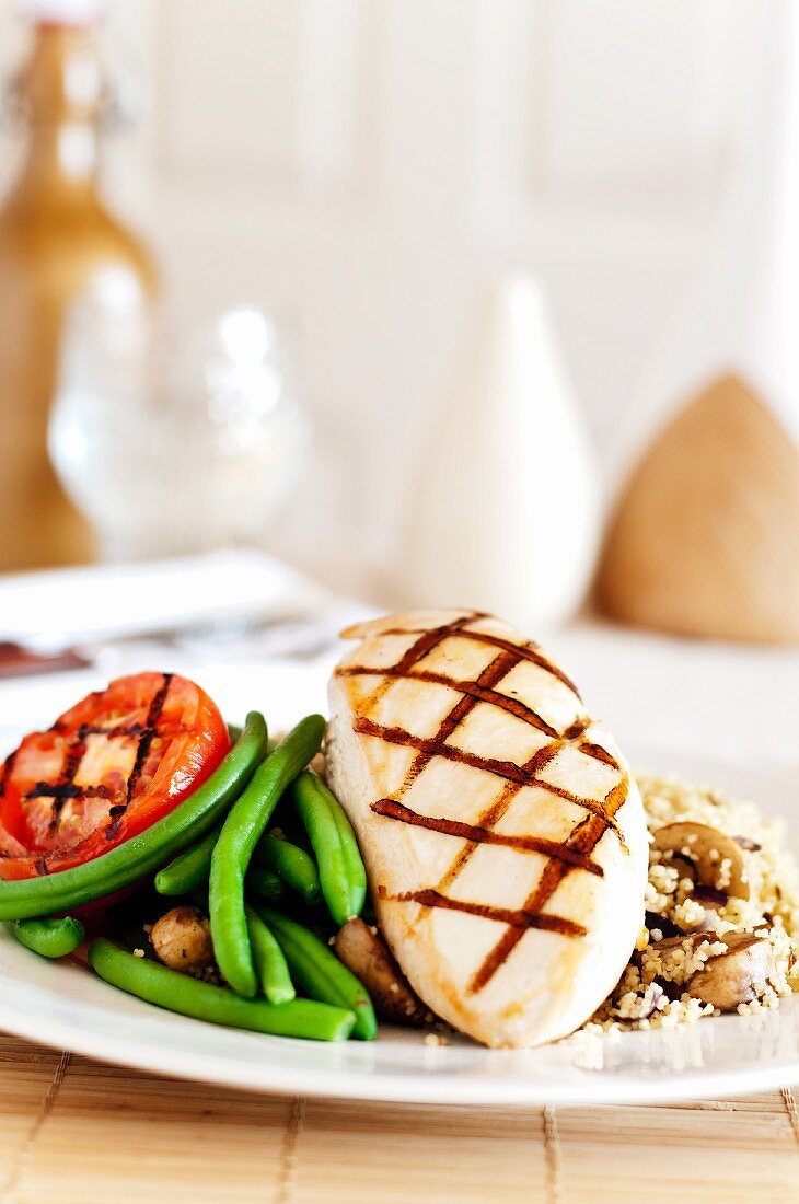Grilled chicken breast with green beans, tomatoes, couscous and mushrooms