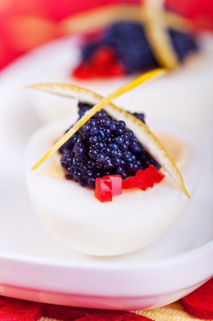 Gekochtes Ei mit Seehasenkaviar, rote Paprikawürfeln und Zitronenzeste