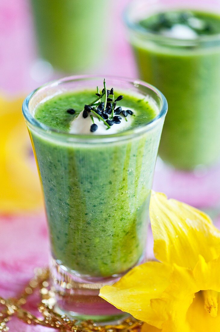 Cream of pea and coriander soup with creme fraiche served in glasses