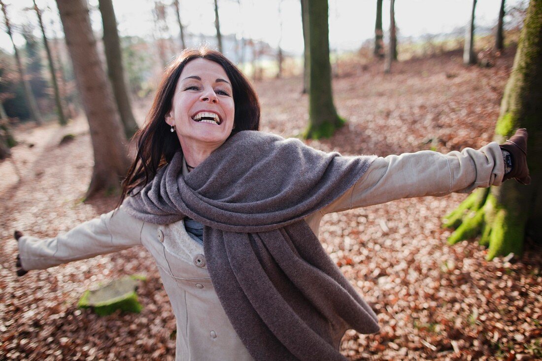 Brünette Frau geht im Wald spazieren