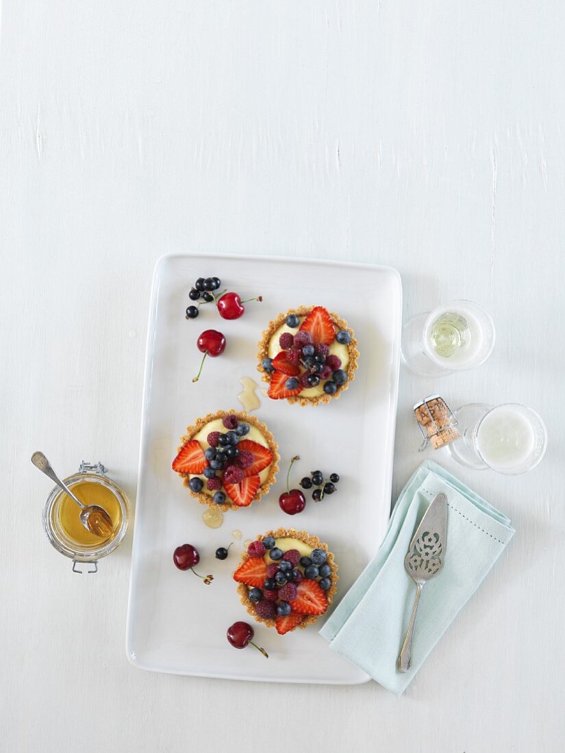 Berry tartlets and a glass of champagne, seen from above