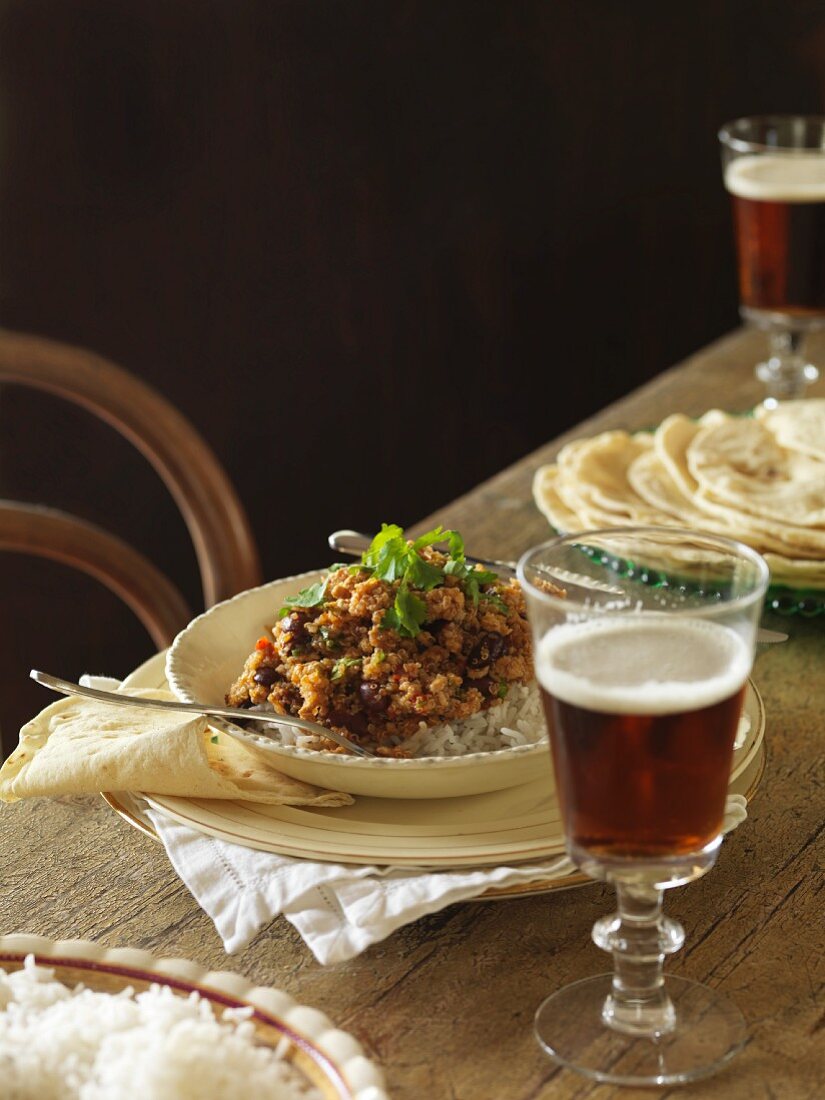 Schweinefleisch-Chili mit Reis und Bier